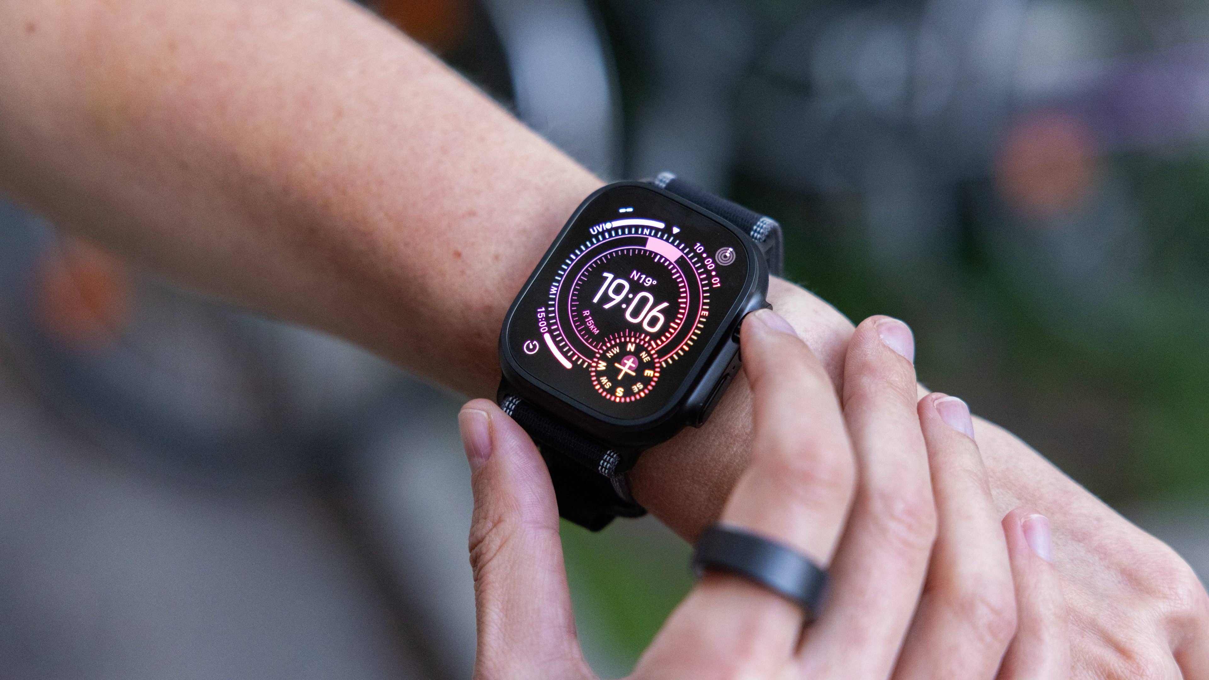A close-up of an Apple Watch Ultra displaying the time 19:06 on a person's wrist.