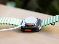 Close-up of an Apple Watch Ultra 3 with a green strap, showing the back and charging port.
