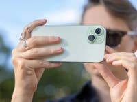 A person taking a picture with the Apple iPhone 15