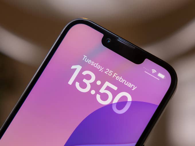 Close-up of an iPhone 16e showing the time 13:50 and the date Tuesday, February 25.