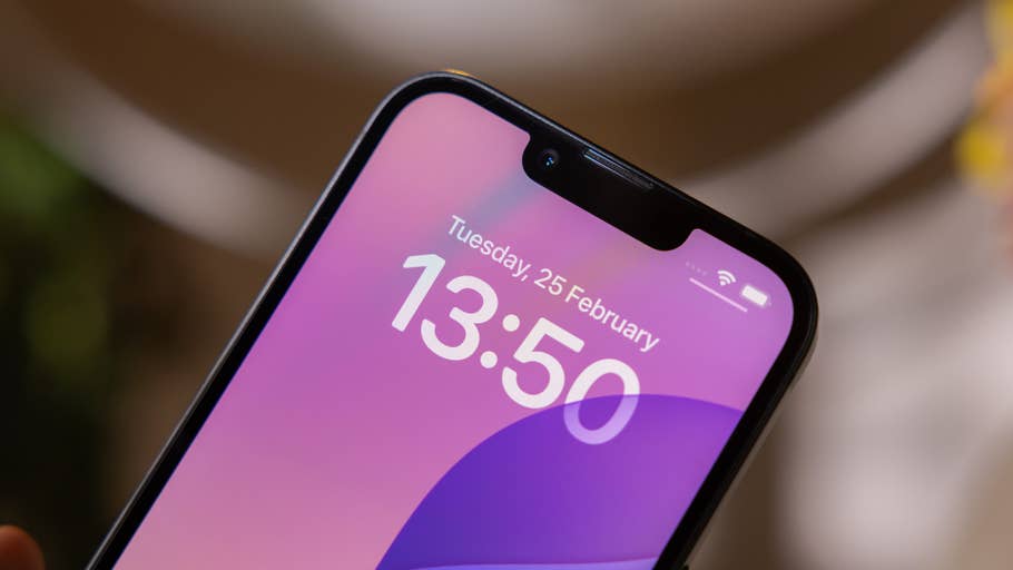 Close-up of an iPhone 16e displaying the time 13:50 and the date Tuesday, 25 February.