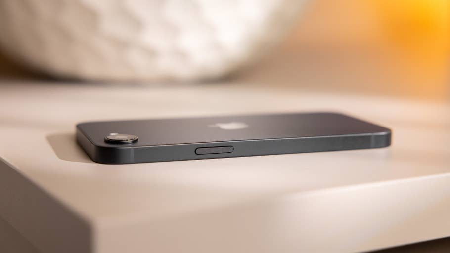 A close-up of an Apple iPhone 16e lying on a table.