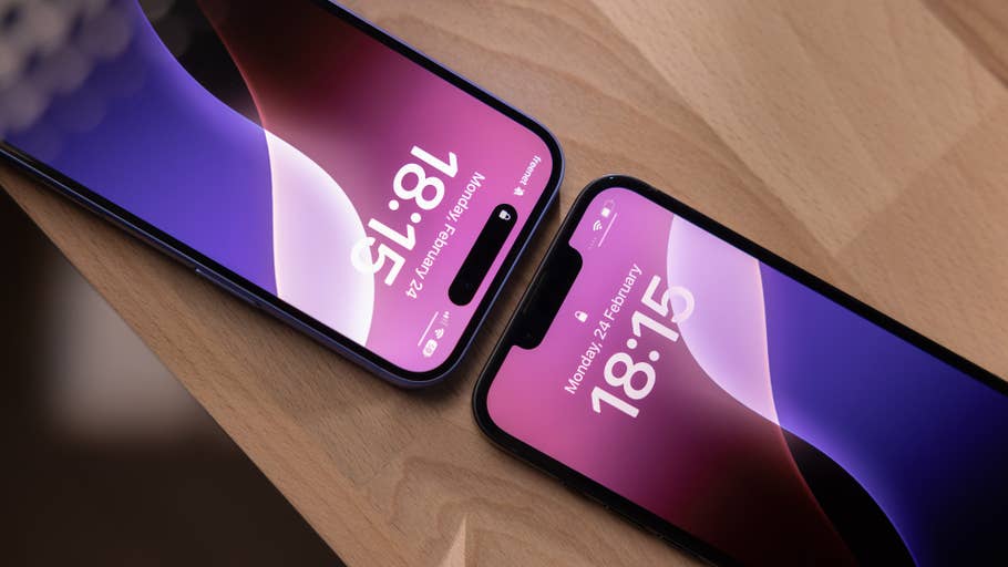 Two iPhones displaying the time: 18:15 and 18:13 on a wooden surface.