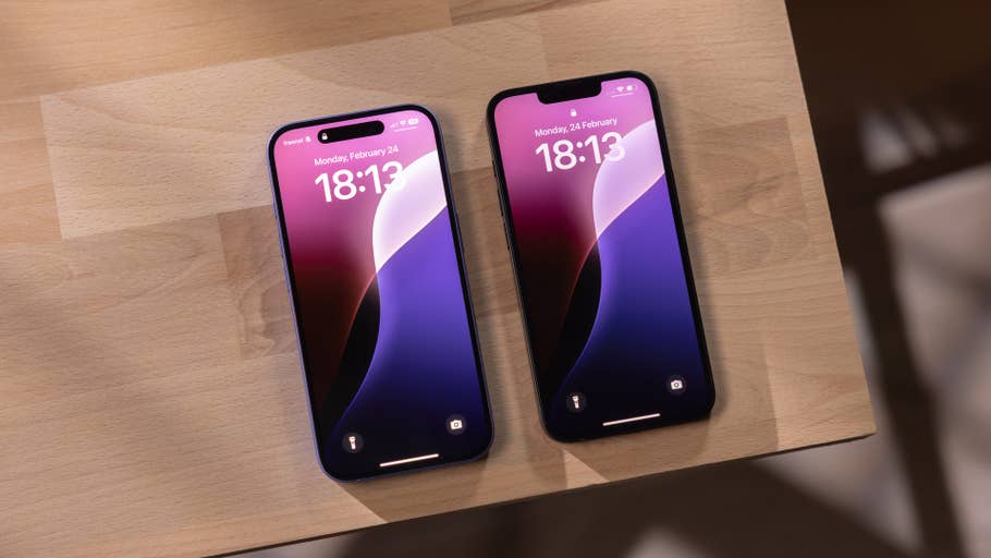 Two Apple iPhones displaying the time 18:13 on a wooden surface.