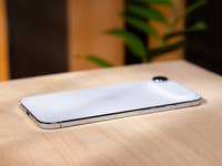 A white Apple iPhone Air lies on a wooden surface.