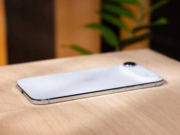 A white Apple iPhone Air lies on a wooden surface.