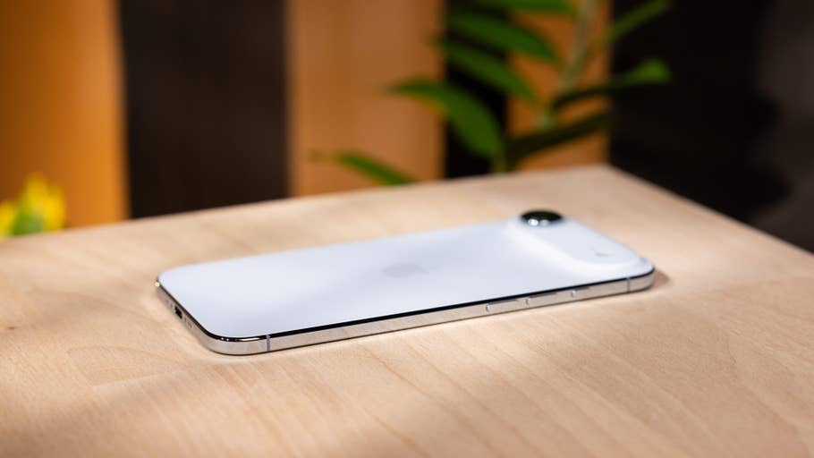 A white Apple iPhone Air lies on a wooden surface.