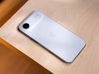 A white Apple iPhone on a wooden surface.