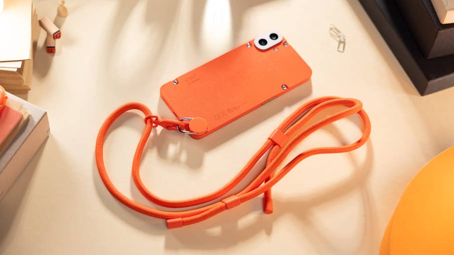 The CMF Phone 1 placed flat on a table and seen from behind with its attached lanyard.
