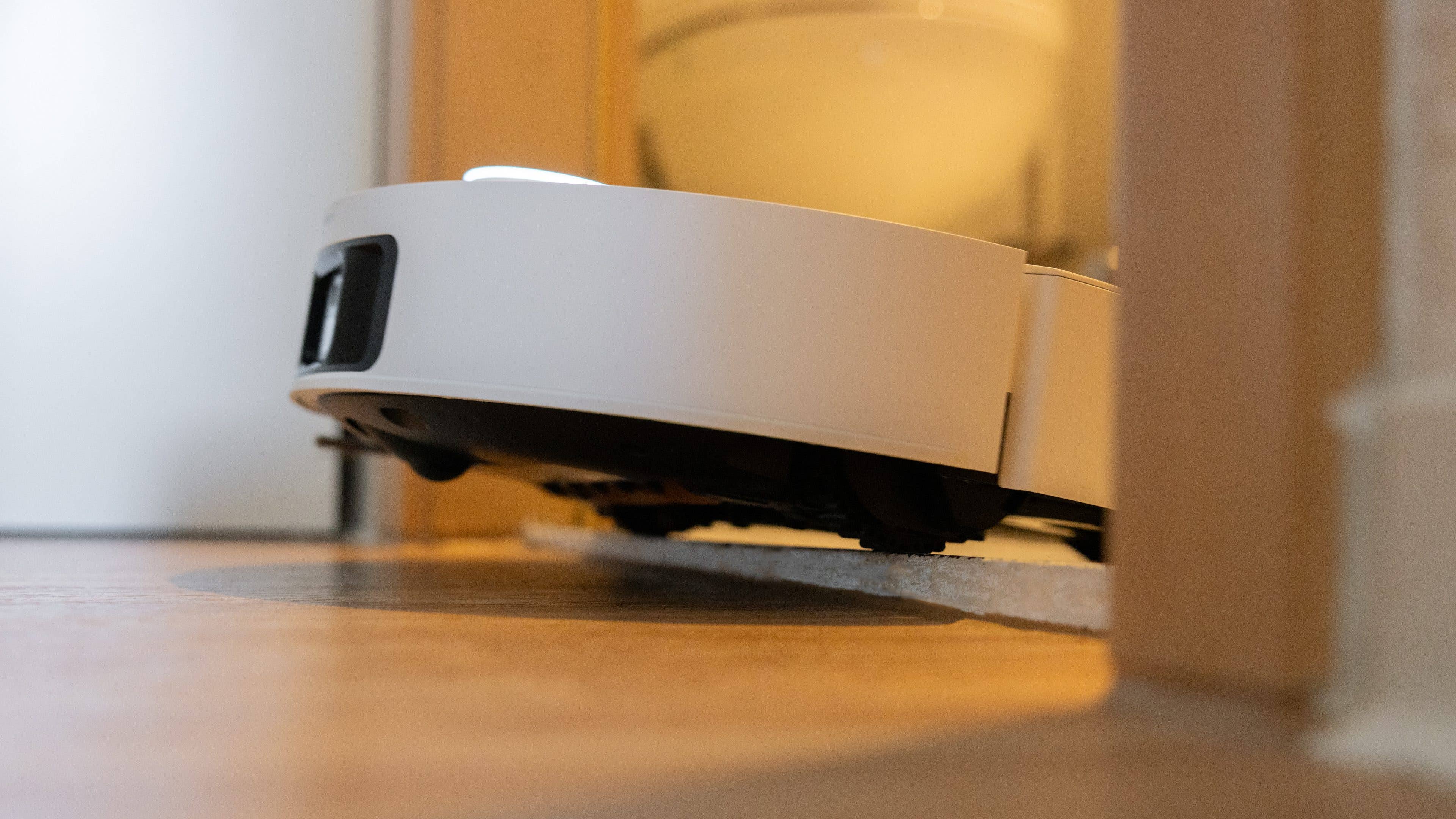 A low-angle view of the Dreame X50 Ultra robot vacuum navigating on a wooden floor.