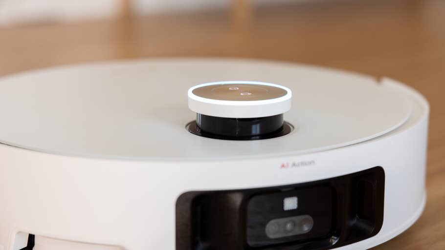 A close-up of the Dreame X50 Ultra robot vacuum cleaner with its control button and sensor.