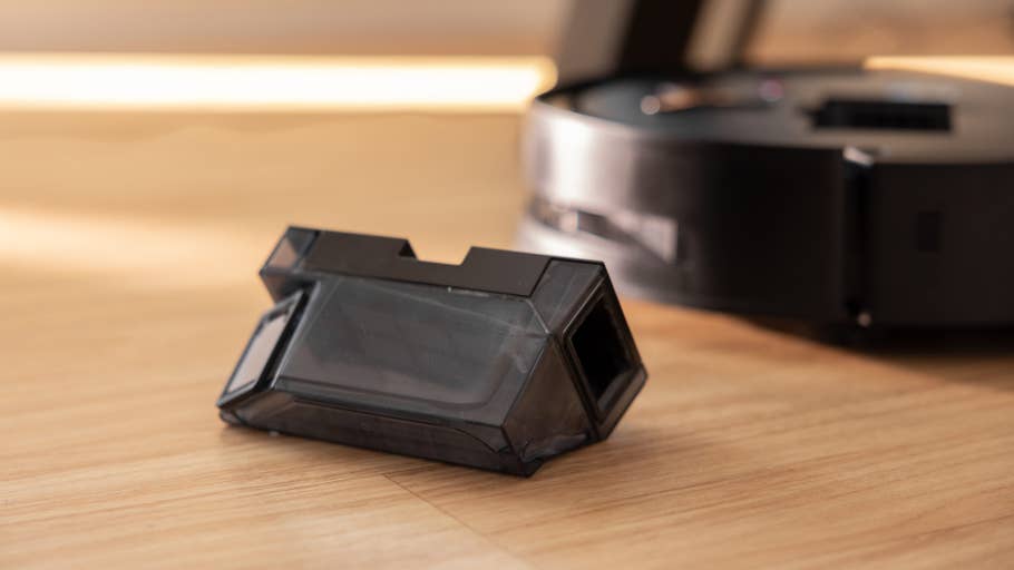 A black Ecovacs Deebot X8 Pro Omni part on wooden floor.