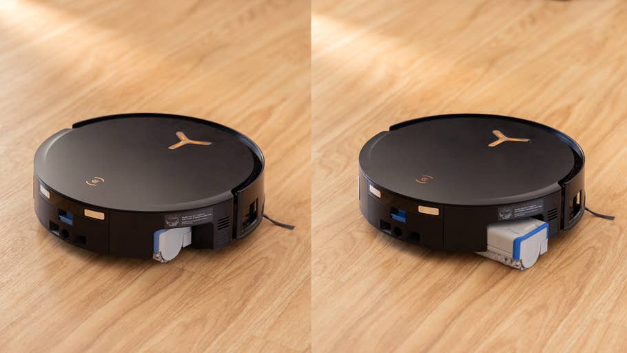 Black round robot vacuum cleaner on a wooden floor.