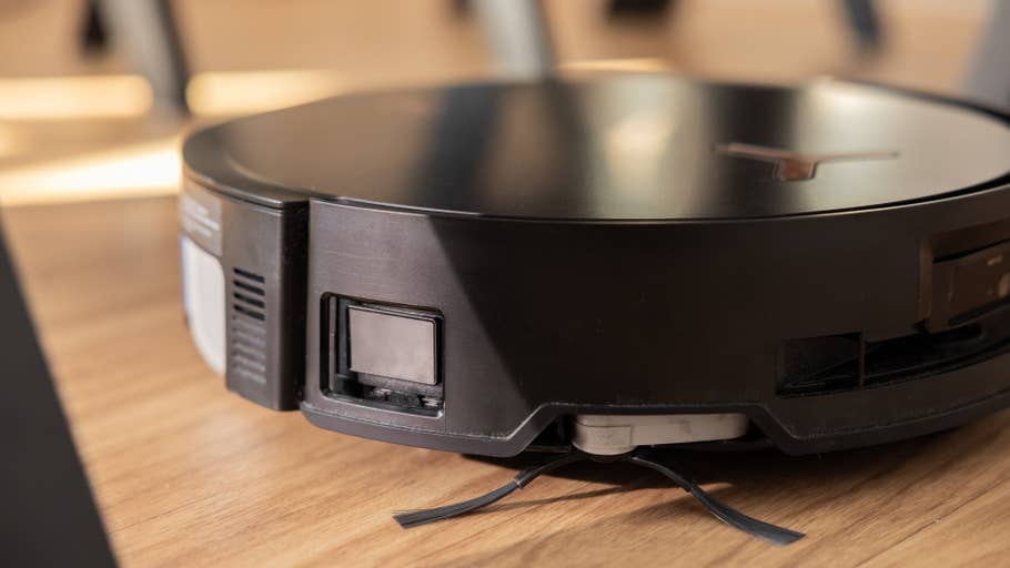 Close-up of the Ecovacs Deebot X8 Pro Omni robot vacuum cleaner on a wooden floor.