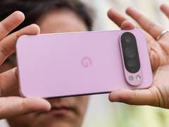 A person holding a Google Pixel 9 Pro smartphone, showing its back in a soft pink color.