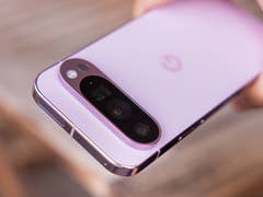 A close-up of a Google Pixel 9 Pro smartphone in a soft pink color, showing its camera module.