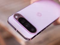 A close-up of a Google Pixel 9 Pro smartphone in a soft pink color, showing its camera module.