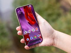 A person holding a Google Pixel 9 Pro smartphone displaying a colorful home screen.