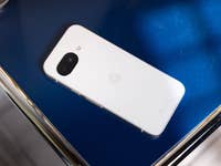 A Google Pixel 9a smartphone resting on a blue surface.
