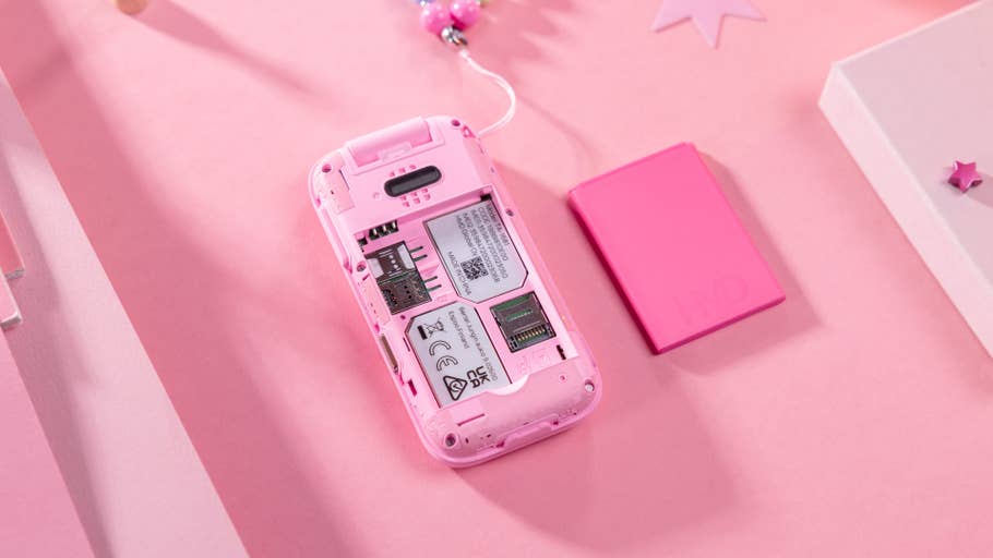 A pink HMD Barbie phone showing its battery compartment and memory card slot on a pink background.