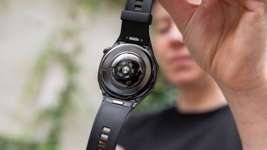 A person holding the back view of a Huawei Watch GT 6 Pro with a black strap.