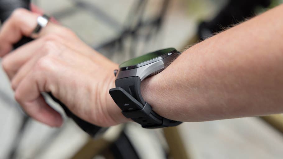 A close-up of a Huawei Watch GT 6 Pro on a personu0027s wrist while holding a bicycle handlebar.