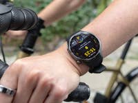 A close-up of a Huawei Watch GT 6 Pro on a person's wrist while holding a bicycle handlebar.