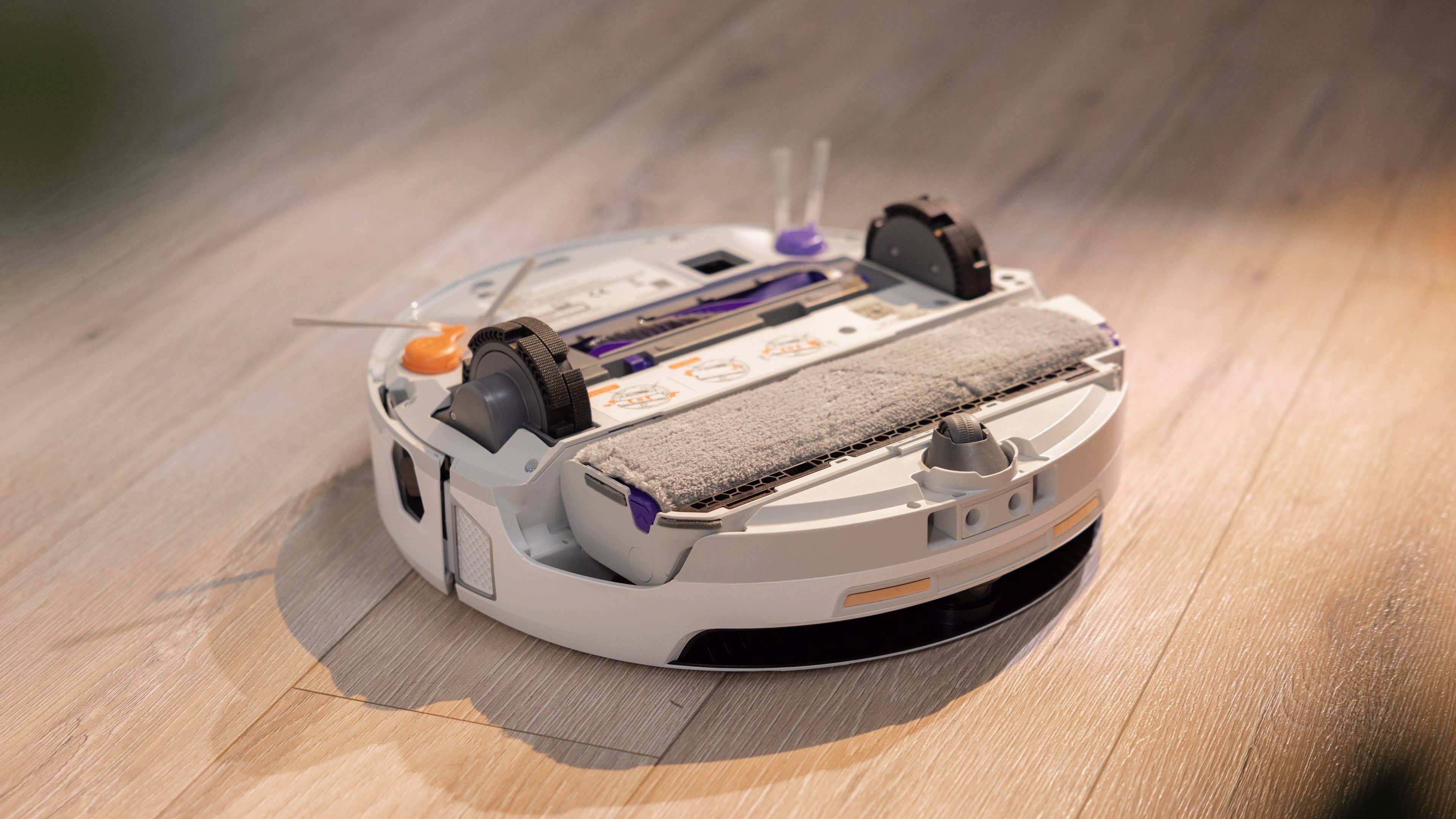 A robotic vacuum cleaner on a wooden floor, designed for efficient cleaning.