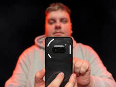 Handheld Nothing Phone (2a) with nextpit's editor behind