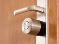 Close-up of a Nuki Smart Lock Pro mounted on a wooden door.