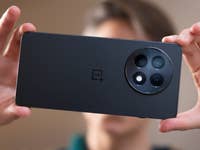 A person holding the back of a OnePlus 13R smartphone, showcasing its camera design.
