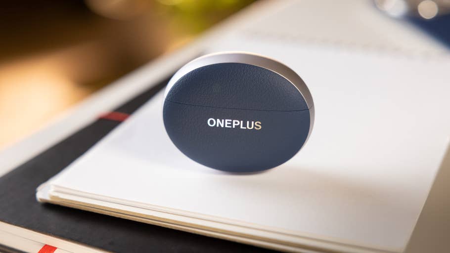 A blue OnePlus earbuds case with the logo on a notepad.