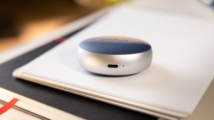 The OnePlus Buds Pro 3 charging case on a notebook.