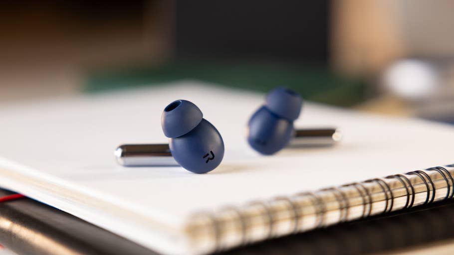 A pair of blue wireless earbuds on a notebook.