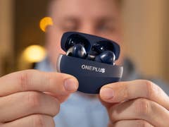 A person holding a navy blue OnePlus Buds Pro 3 case with earbuds inside.