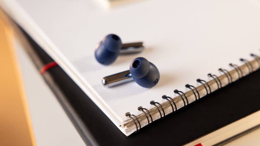 A pair of OnePlus Buds Pro 3 wireless earbuds on a white notepad.