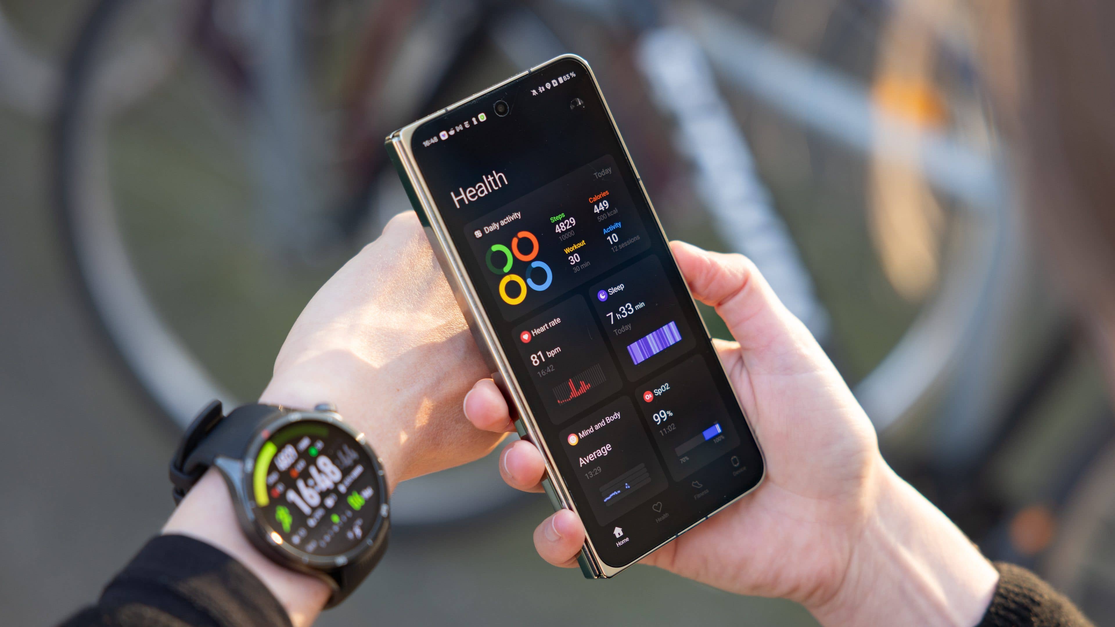 A person checks health statistics on a smartphone while wearing a OnePlus Watch.