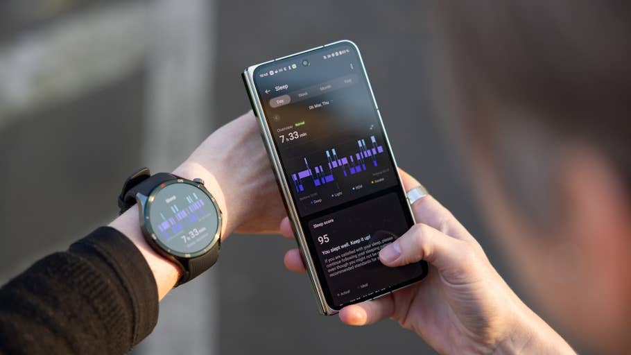 A person checking sleep data on a smartphone while wearing a OnePlus watch on their wrist.