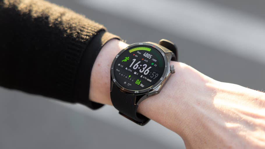 A wrist displaying a OnePlus Watch 3 with a green and black digital interface showing time and fitness stats.
