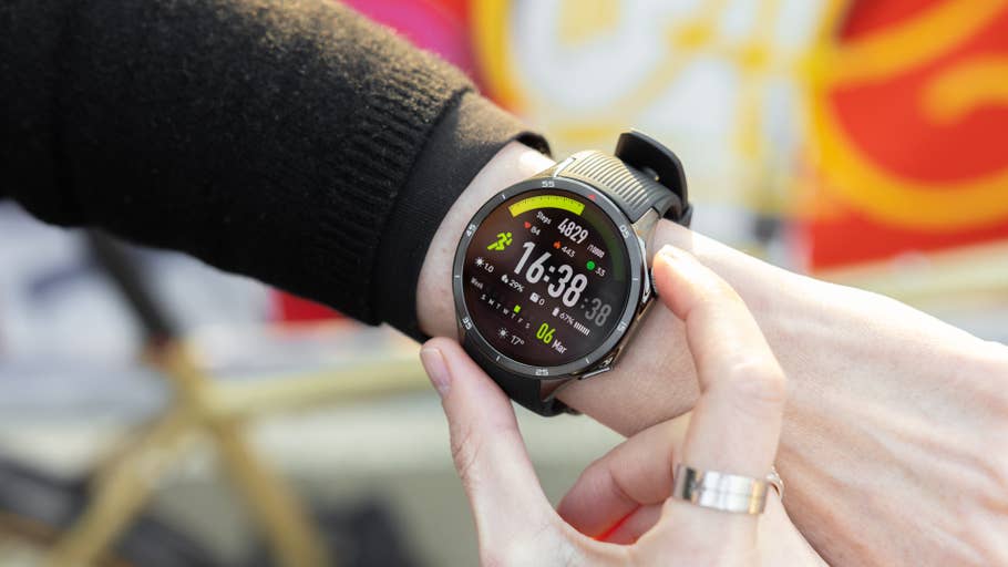 A person is checking a OnePlus Watch 3 on their wrist, showing the time as 16:38:38 and workout metrics.