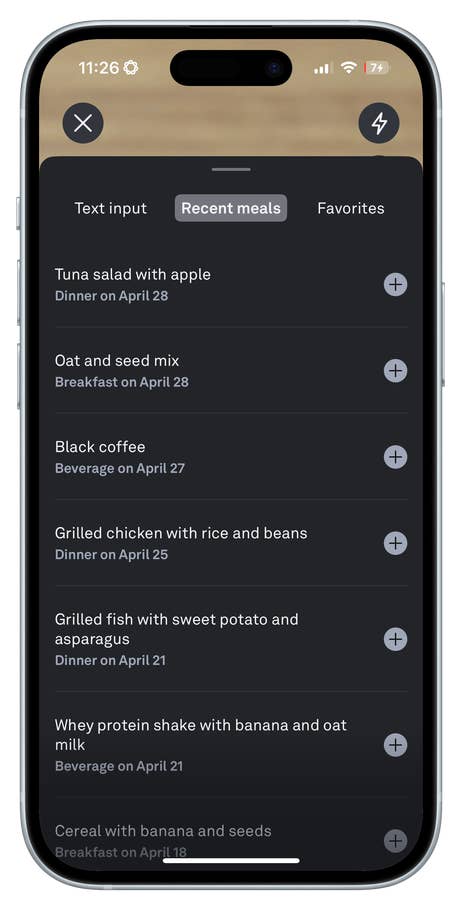 A smartphone displaying a food logging app with recent meals listed, including tuna salad and grilled chicken.