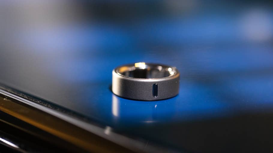 A close-up of the Oura Ring 4 resting on a reflective surface.