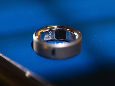 A close-up of an Oura Ring 4 lying on a blue surface, showcasing its sleek design.