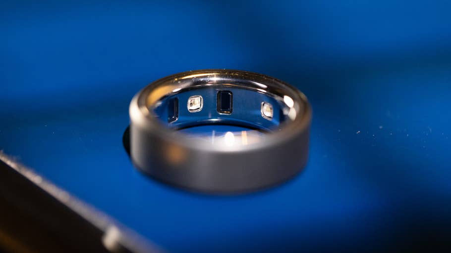 A close-up of an Oura Ring on a blue surface.