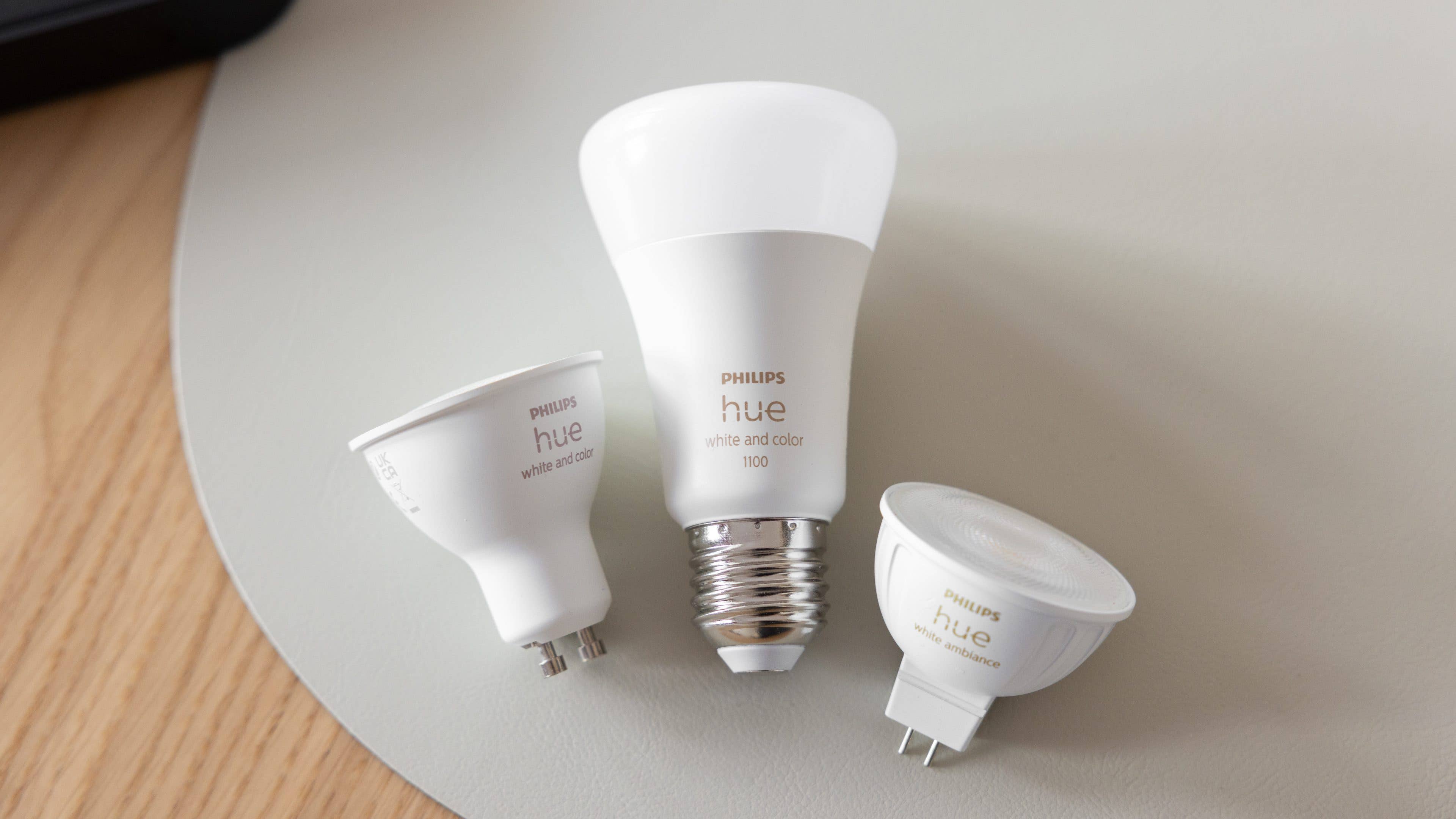 Three Philips Hue smart light bulbs on a light surface. Three Philips Hue smart light bulbs on a light surface.