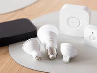 A collection of Philips Hue smart light bulbs and accessories on a wooden surface.