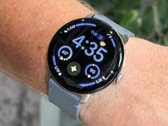 A Google Pixel Watch 4 displaying the time 4:35 and various health metrics on a wrist.