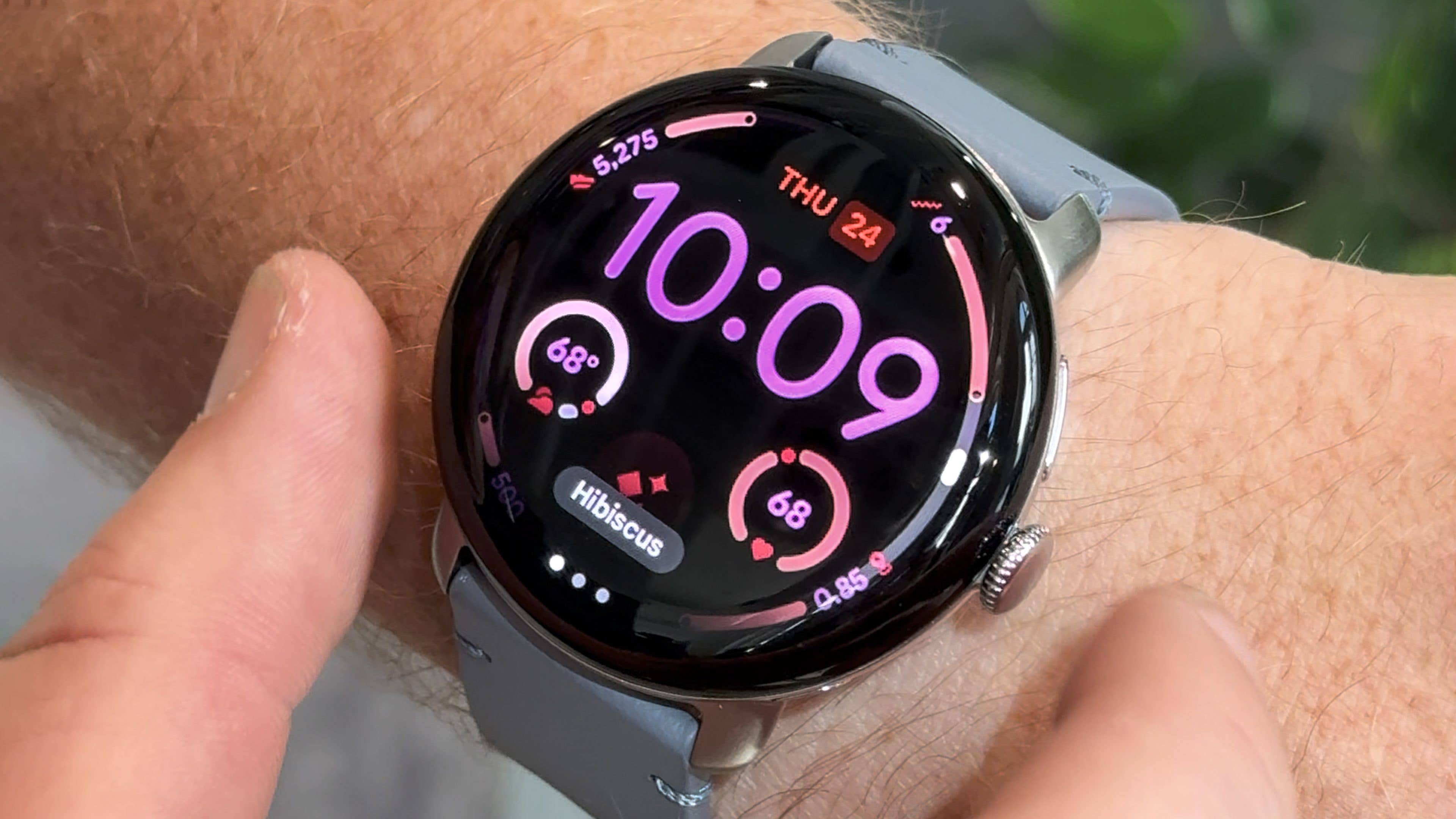 A Google Pixel Watch 4 displaying the time 10:09 and fitness stats on a wrist.