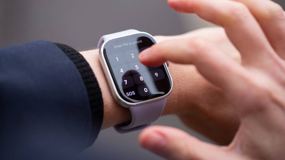 A hand entering a PIN on a Redmi Watch 5 touchscreen.