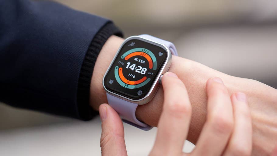 A hand wearing a Redmi Watch 5 displaying the time 14:28 and various health metrics.